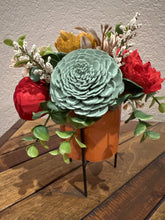 Sola wood flowers in orange ceramic container with black stand