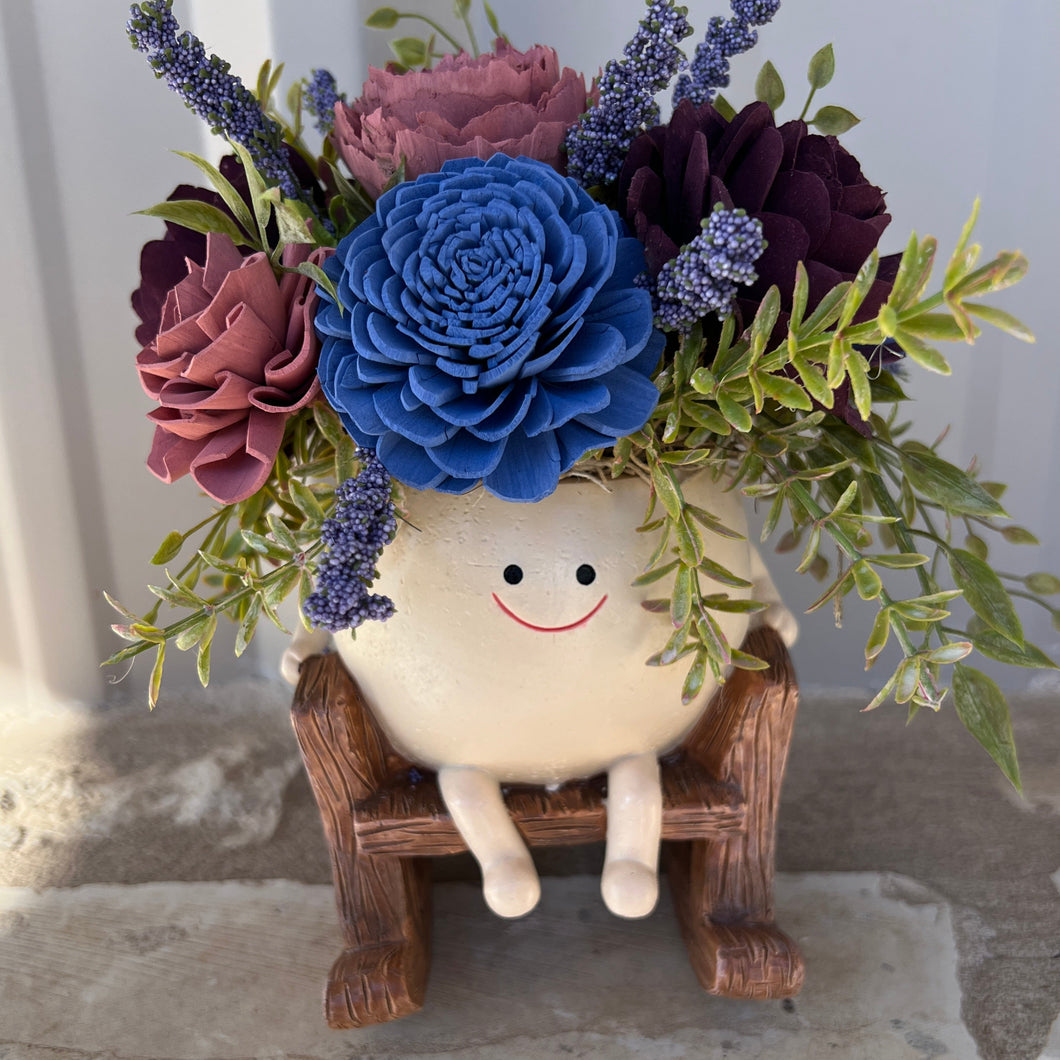 Sola wood flowers arranged in “Humpty Dumpty “ in rocking chair