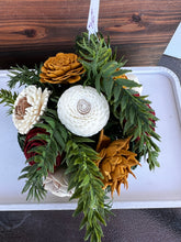 Sola Wood flower arrangement in container with trees on it.