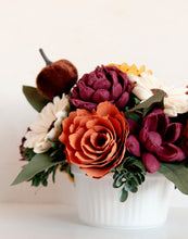 Sola Wood flowers arranged in a small ceramic dish