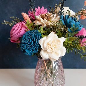 Sola wood floral arrangement in pink glass container