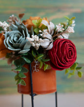 Sola wood flowers in orange ceramic container with black stand